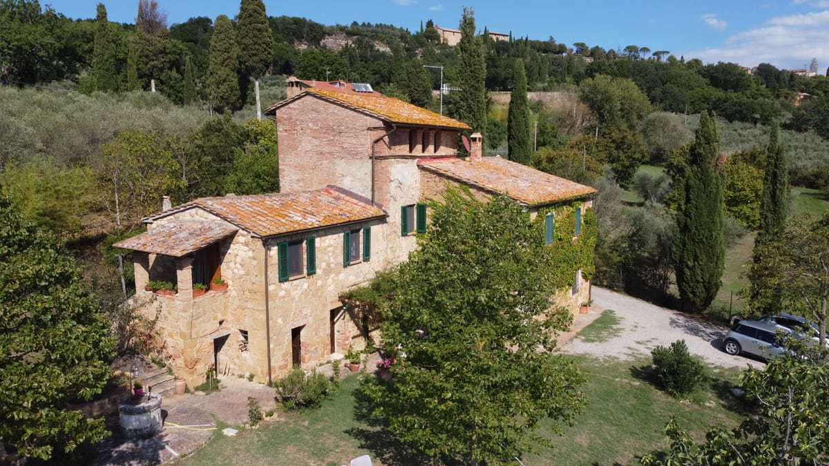The farmhouse from above: the tiled roof, the dovecote tower and the pergola in front of the apartment