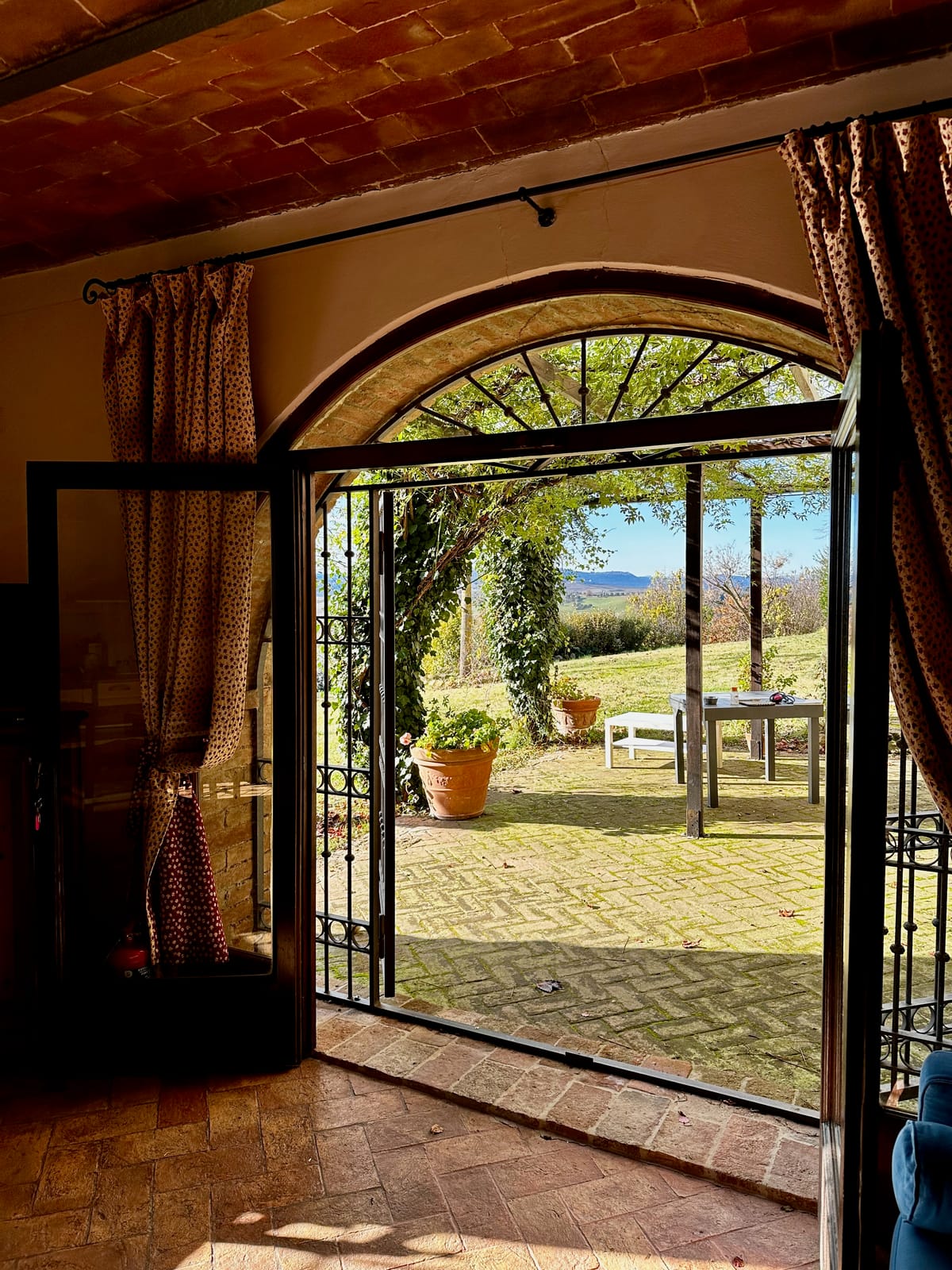 The brick archway opening from the apartment onto the pergola and lawn