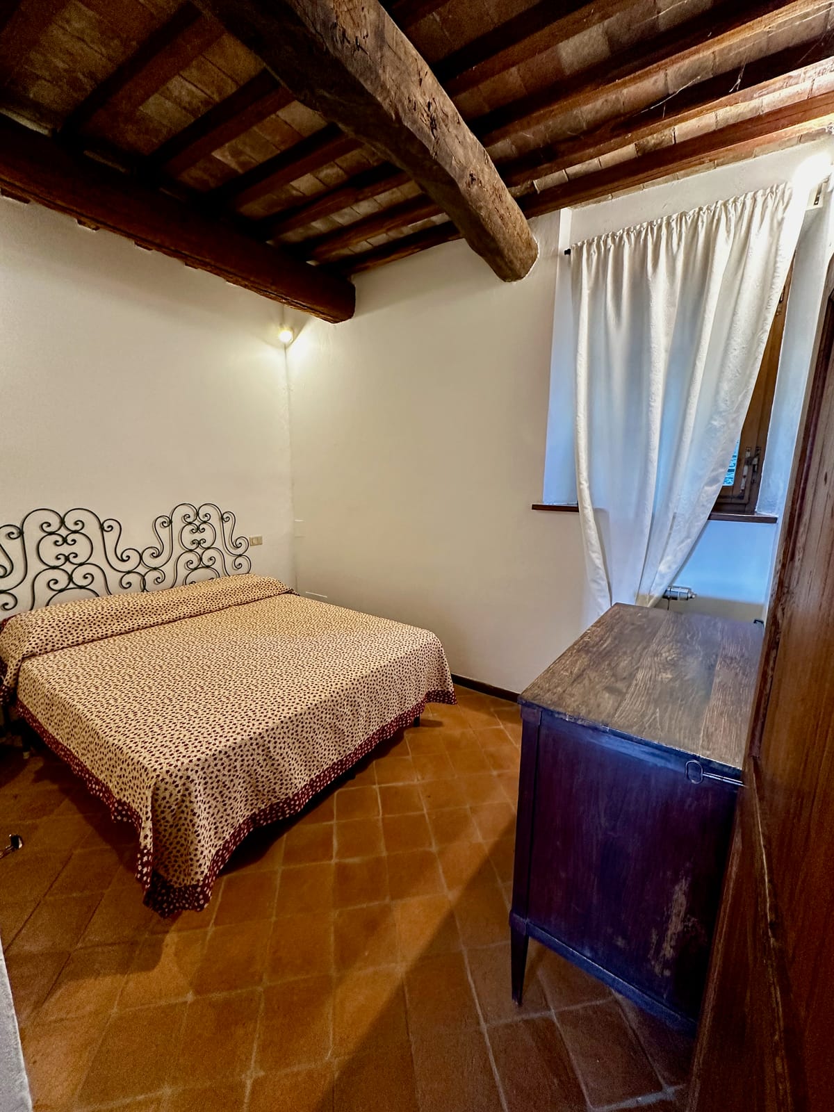 The double bedroom with wrought-iron headboard and exposed beams