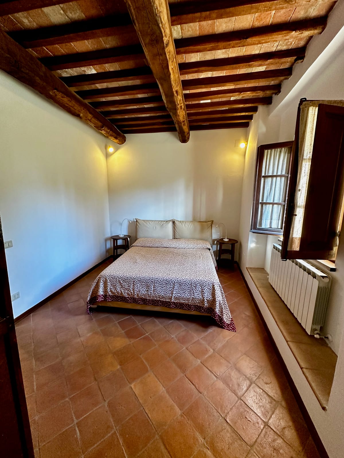 Bedroom with beamed-and-tiled ceiling and terracotta floor