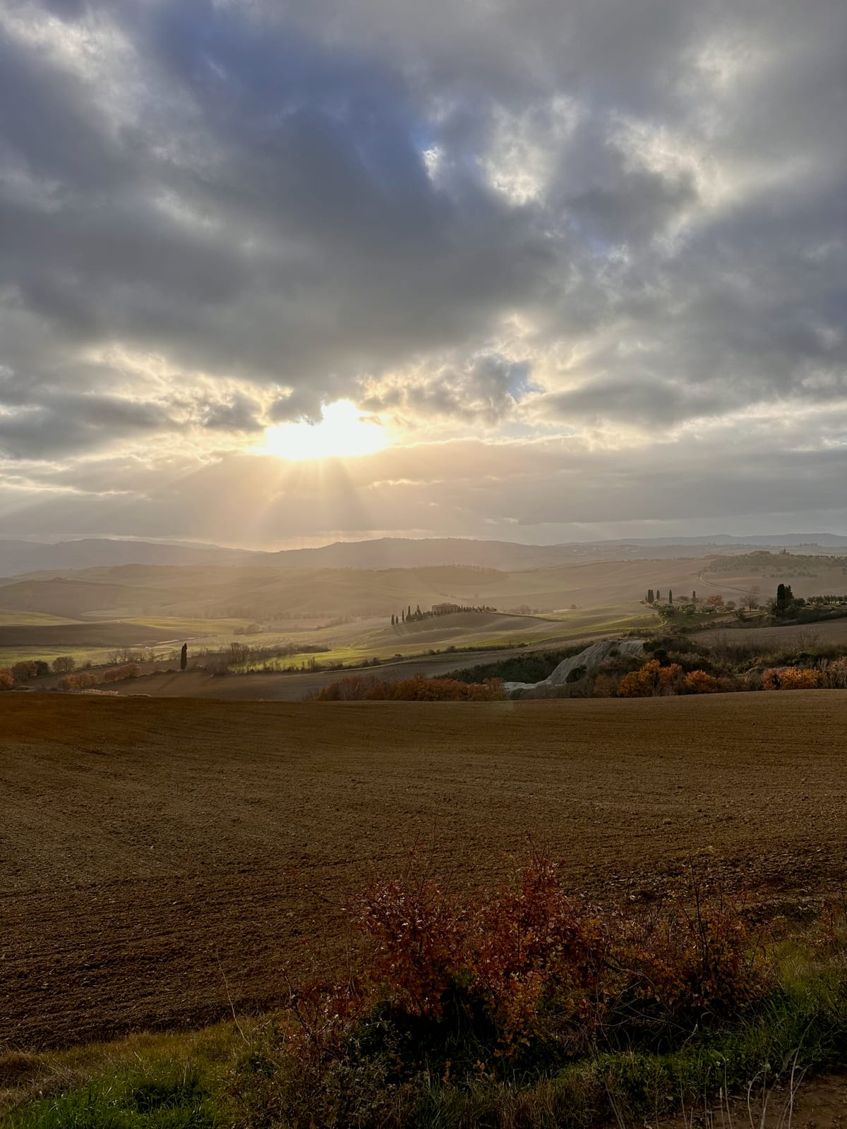 Sunbeams breaking through the clouds at dawn over the valley