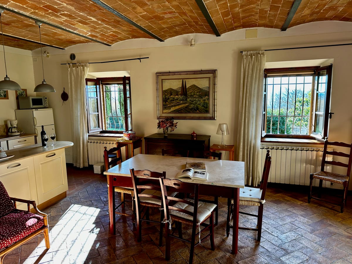 The dining table between the two windows, under the vaulted ceiling