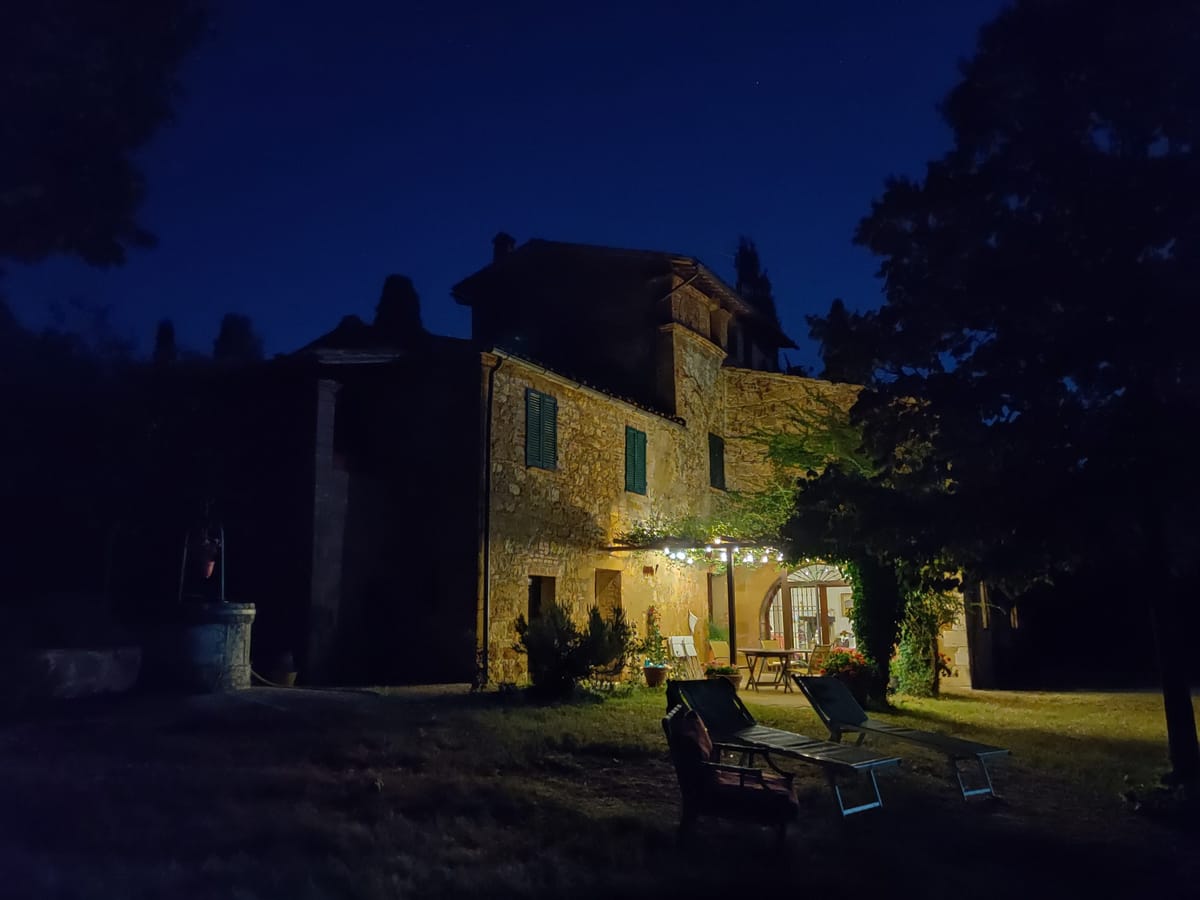 Lit windows and chairs on the lawn, on an August evening