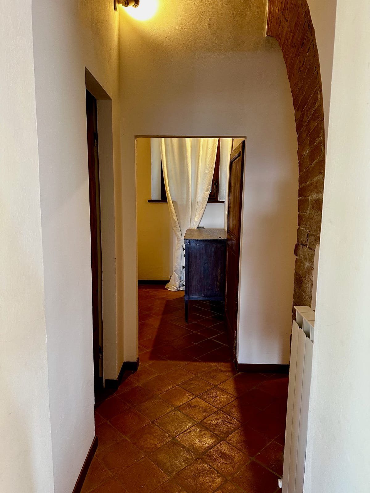 The hallway connecting the bedrooms, with its terracotta floor