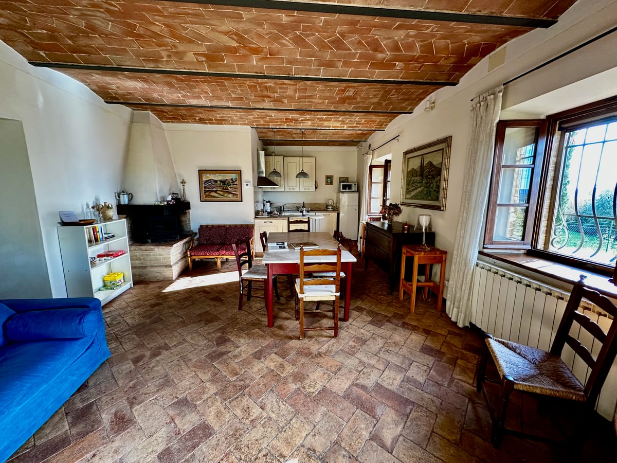 The living room with sofa, dining table and terracotta floor