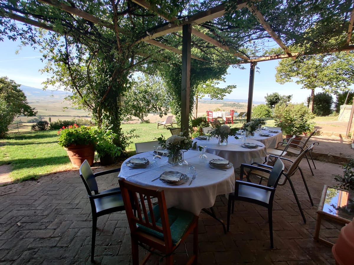 The table laid under the pergola, in the shade of the vine, ready for lunch