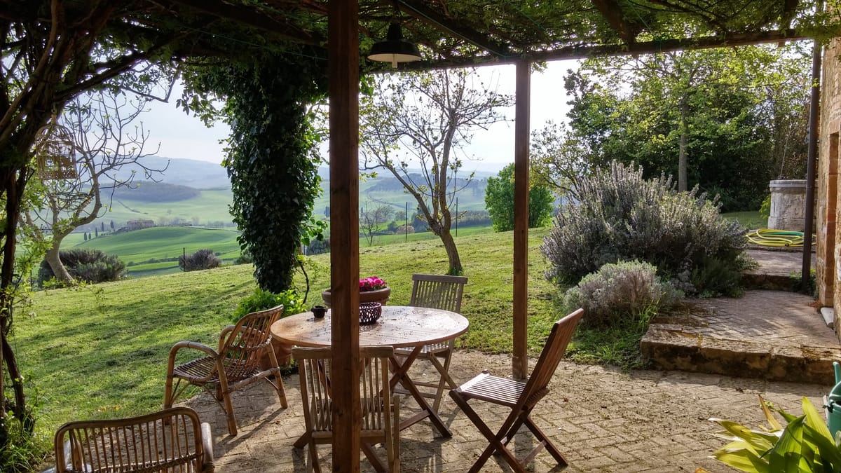 The table and chairs under the pergola in April, the valley opening up in front